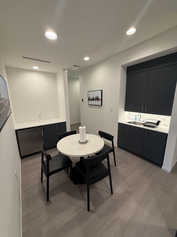 Kitchenette with sink, cabinets and café table
