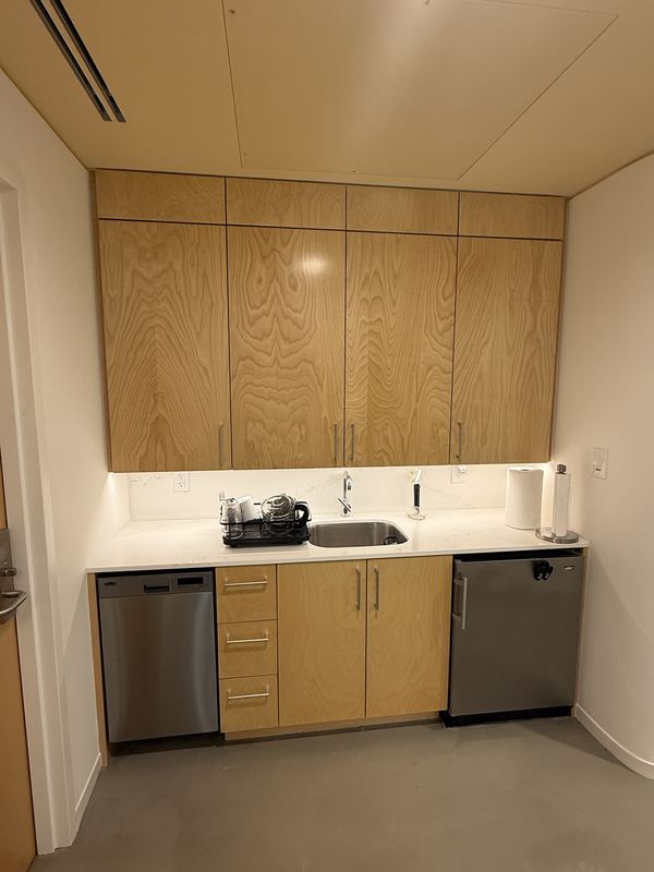 Kitchenette with wood cabinets, sink, dishwasher and small refrigerator